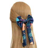 Colorful hair bow on a person's head with a plain background
