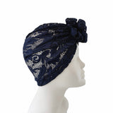 Navy blue lace headscarf on a mannequin head against a white background