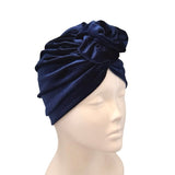 Navy blue turban on a mannequin head against a white background