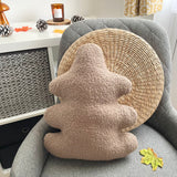 Decorative pillow shaped like a oak leaf on a gray chair with a woven round pillow.