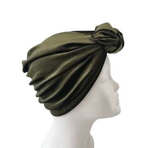 Green headscarf on a mannequin head against a white background