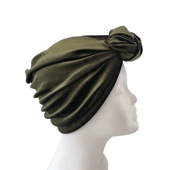 Green headscarf on a mannequin head against a white background