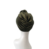 Green headscarf on a mannequin head against a white background