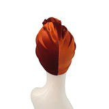 Brown velvet turban on a mannequin head against a white background