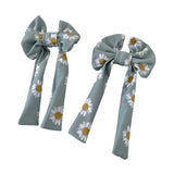 Two decorative bows with daisy patterns on a light blue background