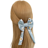 Hair bow with floral pattern tied in a ponytail on a white background