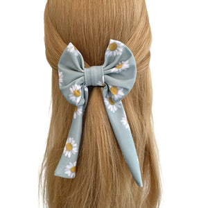 Hair bow with floral design on a person's head against a white background