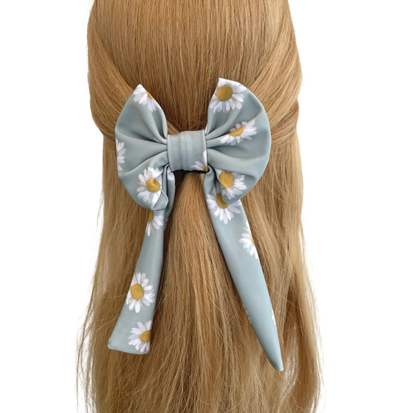 Hair bow with floral design on a person's head against a white background