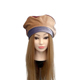 Mannequin head with a beige and purple hat on a white background