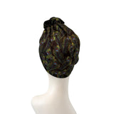 Black headscarf with peacock feather pattern on a white mannequin head.