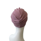 Mauve turban on a mannequin head against a white background