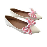White flats with pink leopard print bows on a white background