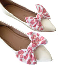 White shoes with pink bows on a white background