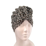 Leopard print turban on a mannequin head against a white background