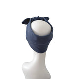 A navy blue fabric headband with two small pointed ear-like tabs on top, displayed on a white mannequin head against a plain white background.