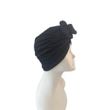 Black turban with a bow on a mannequin head against a white background