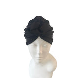 Black headscarf on a mannequin head against a white background