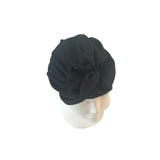 Black turban on a mannequin head against a white background