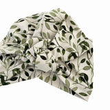fabric turban hat with green leaf pattern on a white background