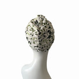 White headscarf with black leaf pattern on a white mannequin head against a white background