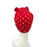 Red headscarf with white polka dots on a mannequin head against a white background