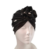 Black headscarf with a bow on a mannequin head against a white background
