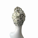 Headscarf with leaf pattern on a mannequin head against a white background
