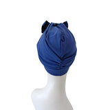 Blue headscarf with a black bow on a mannequin head against a white background