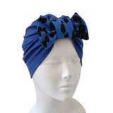Blue headscarf with black patterns on a mannequin head against a white background