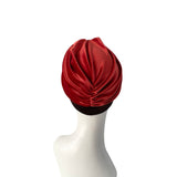 Red turban on a mannequin head against a white background
