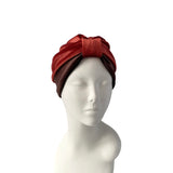 Red turban on a mannequin head against a white background