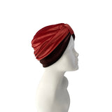 Red and brown turban on a mannequin head against a white background