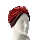 Red and brown turban on a mannequin head against a white background