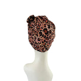 Leopard print headscarf on a mannequin head against a white background