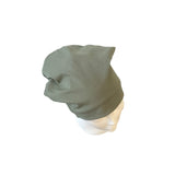 Green beanie on a mannequin head against a white background