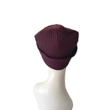 Purple knit beanie on a mannequin head against a white background