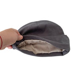 Gray fabric turban held by a hand on a white background