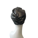 Black turban on a white mannequin head against a white background