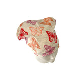 Beige fabric with colorful butterfly patterns on a white background