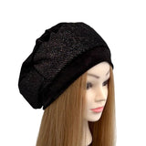 Black beret on a mannequin head with long brown hair against a white background