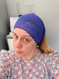 Person wearing a blue lace headband in an indoor setting