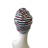 Striped headscarf with cherry pattern on a mannequin head against a white background