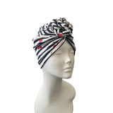 Navy and white striped headscarf with cherry pattern on a mannequin head against a white background