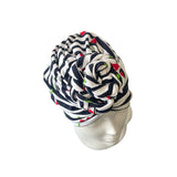 Navy and white patterned headscarf on a mannequin head against a white background