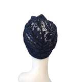 Navy blue lace headscarf on a mannequin head against a white background