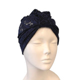 Navy blue headscarf with lace details on a mannequin head against a white background