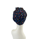 Colorful patterned headscarf on a mannequin head against a white background