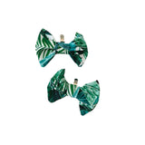 Two green leaf-patterned clips on a white background