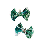 Two green and white leaf-patterned bows on a white background
