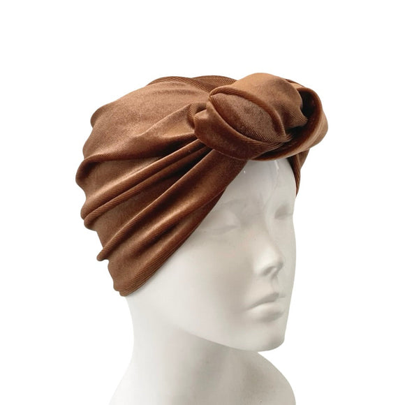 Brown turban on a mannequin head against a white background